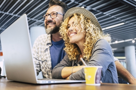 Happy and cheerful people couple with computer